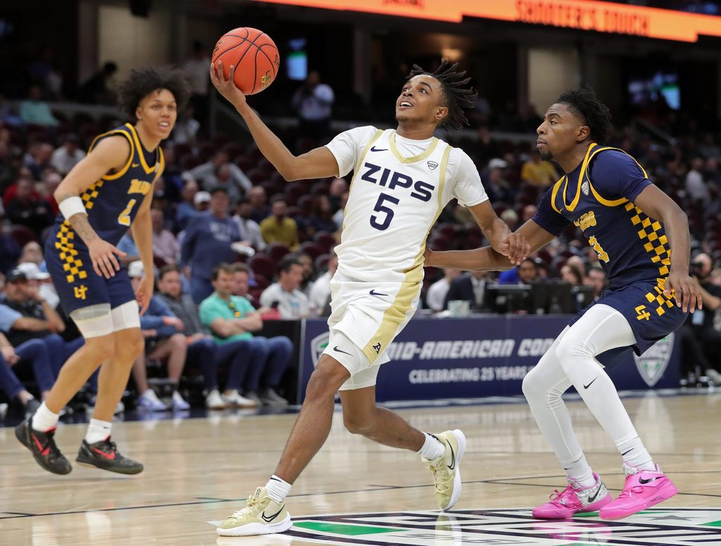 Akron Zips guard Tavari Johnson goes to the basket ahead of Toledo guard Sonny Wilson in the first half of a Mid-American Conference Tournament semifinal, Friday, March 14, 2025, in Cleveland.