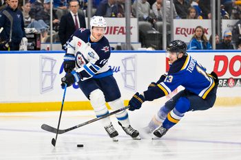Dec 17, 2025; St. Louis, Missouri, USA; Winnipeg Jets right wing Gustav Nyquist (14) controls the puck as St. Louis Blues right wing Alexey Toropchenko (13) defends during the second period at Enterprise Center. Mandatory Credit: Jeff Curry-Imagn Images