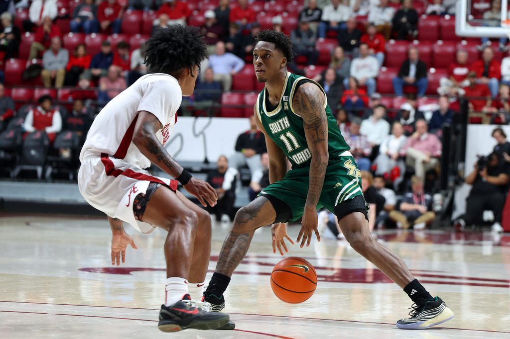 Dec 17, 2025; Tuscaloosa, Alabama, USA; South Florida Bulls guard CJ Brown (11) dribbles against Alabama Crimson Tide guard Aden Holloway (2) during the second half at Coleman Coliseum. Mandatory Credit: David Leong-Imagn Images