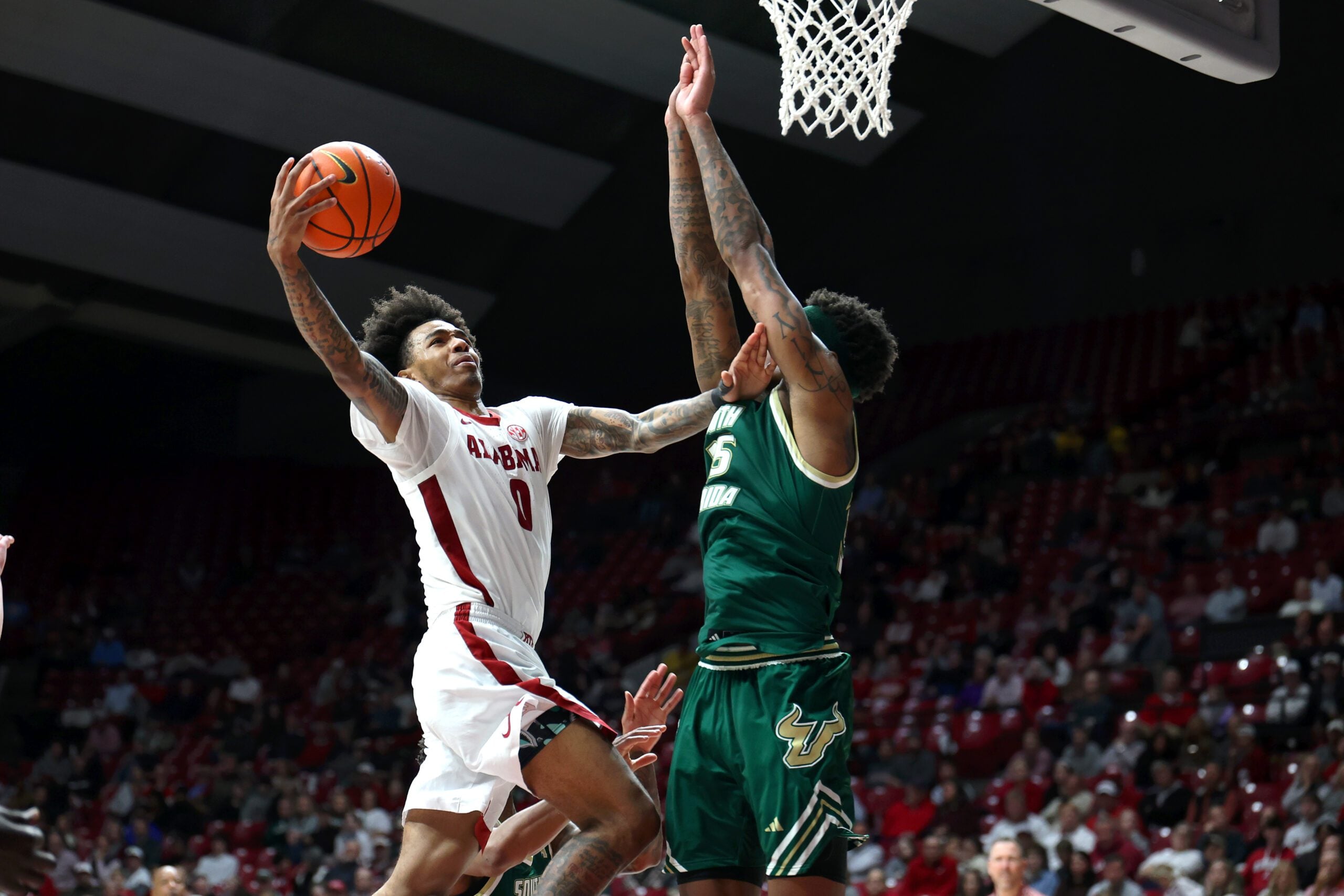 Dec 17, 2025; Tuscaloosa, Alabama, USA; Alabama Crimson Tide guard Labaron Philon (0) drives against South Florida Bulls forward Izaiyah Nelson (35) during the second half at Coleman Coliseum. Mandatory Credit: David Leong-Imagn Images