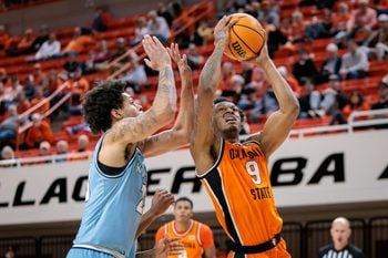 Dec 18, 2025; Stillwater, Oklahoma, USA; Oklahoma State Cowboys guard Anthony Roy (9) shoots the ball around Kansas City Roos forward Addarin Scott (23) during the second half at Gallagher-Iba Arena. Mandatory Credit: William Purnell-Imagn Images
