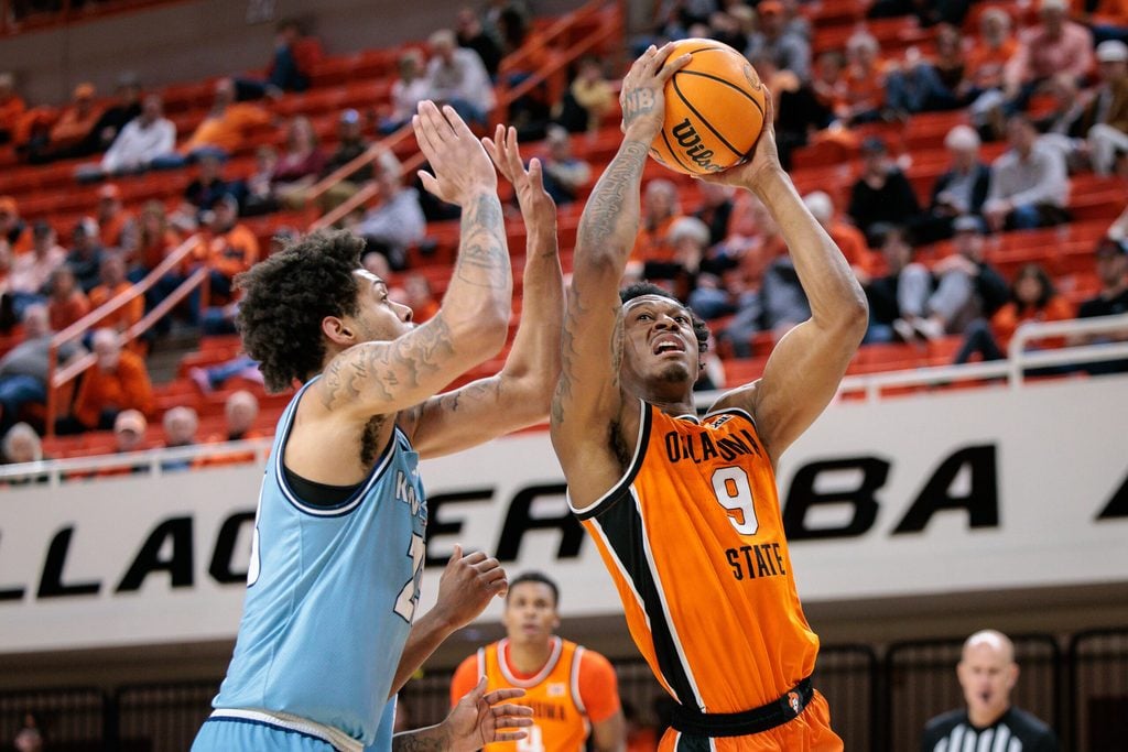 Dec 18, 2025; Stillwater, Oklahoma, USA; Oklahoma State Cowboys guard Anthony Roy (9) shoots the ball around Kansas City Roos forward Addarin Scott (23) during the second half at Gallagher-Iba Arena. Mandatory Credit: William Purnell-Imagn Images