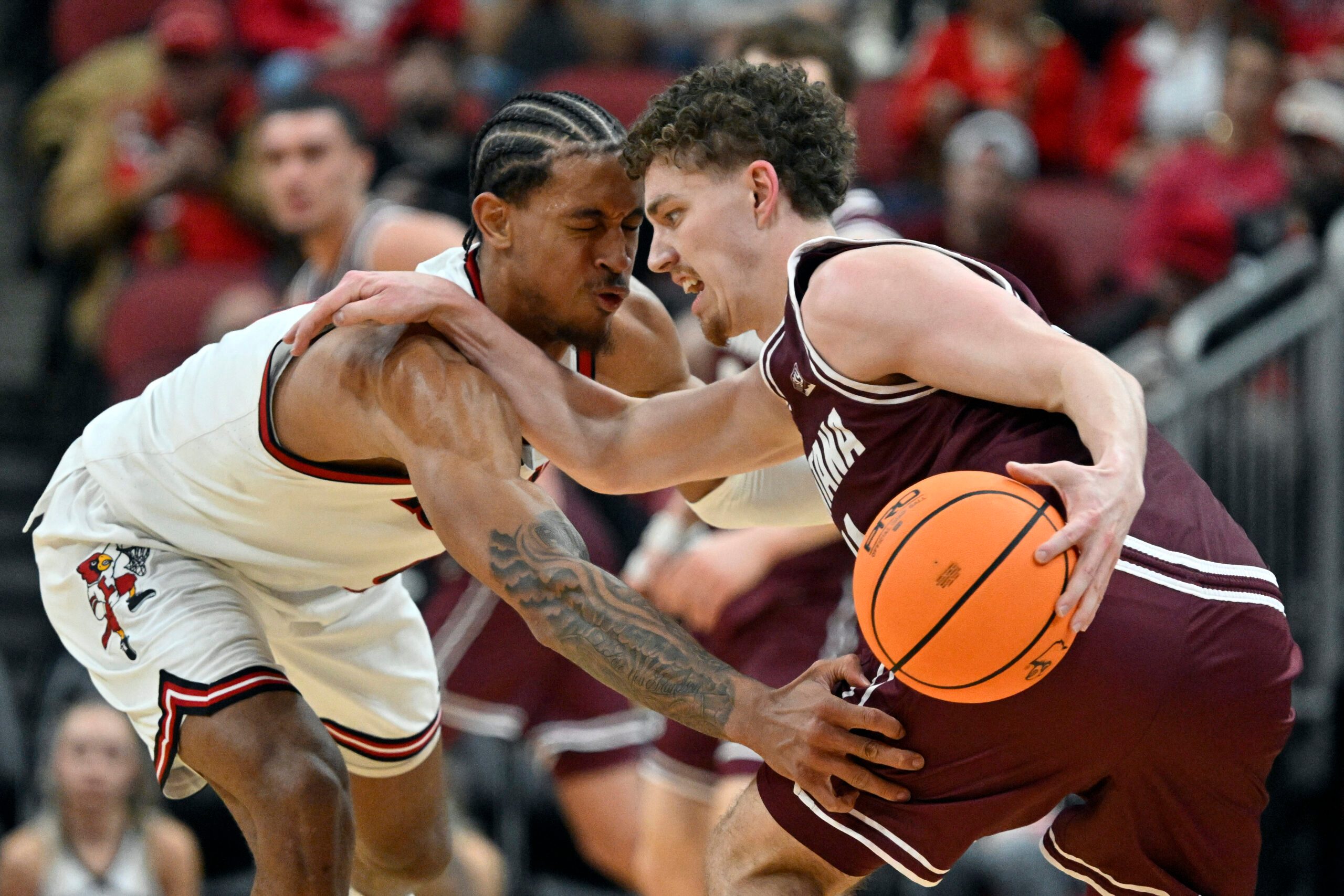 Dec 20, 2025; Louisville, Kentucky, USA;  Montana Grizzlies guard Grant Kepley (11) dribbles under the pressure of Louisville Cardinals forward Khani Rooths (9) during the second half at KFC Yum! Center. Louisville defeated Montana 94-54. Mandatory Credit: Jamie Rhodes-Imagn Images