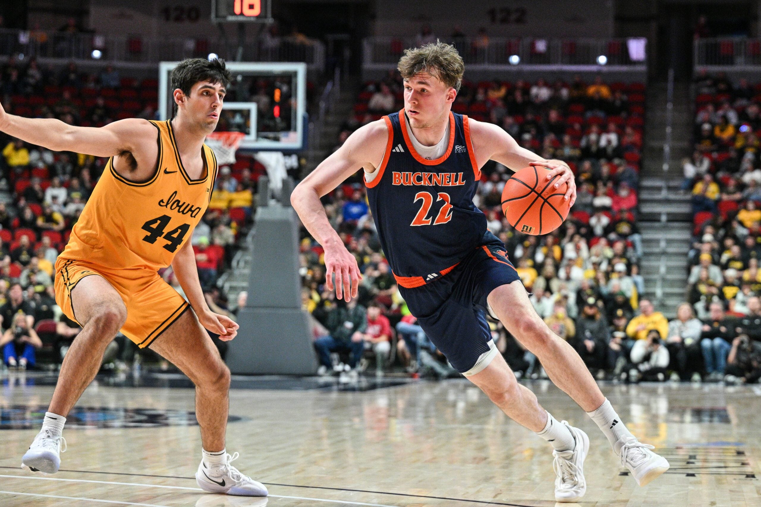 Dec 20, 2025; Iowa City, Iowa, USA; Bucknell Bison forward Amon Dörries (22) controls the ball as Iowa Hawkeyes forward Joey Matteoni (44) defends during the second half at Casey’s Center. Mandatory Credit: Jeffrey Becker-Imagn Images