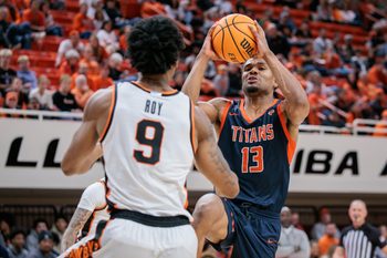 Dec 21, 2025; Stillwater, Oklahoma, USA; Cal State Fullerton Titans guard Jefferson de la Cruz Monegro (13) drives to the basket around Oklahoma State Cowboys guard Anthony Roy (9) during the second half at Gallagher-Iba Arena. Mandatory Credit: William Purnell-Imagn Images