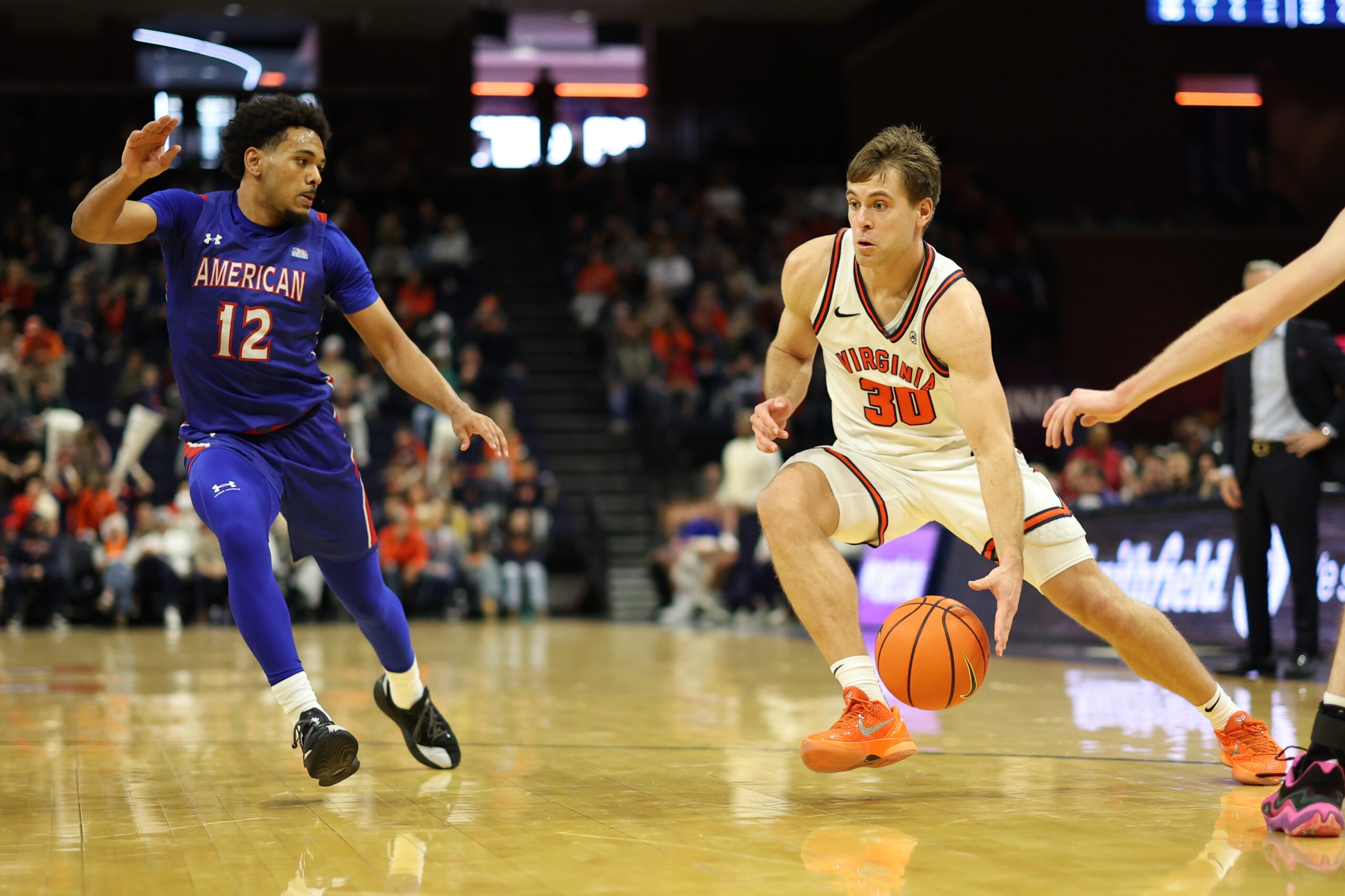 Dec 22, 2025; Charlottesville, Virginia, USA; Virginia Cavaliers guard Dallin Hall (30) drives to the basket as American University Eagles guard Geoff Sprouse (12) defends in the second half at John Paul Jones Arena. Mandatory Credit: Geoff Burke-Imagn Images