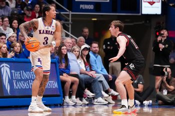 Dec 22, 2025; Lawrence, Kansas, USA; Kansas Jayhawks guard Tre White (3) controls the ball as Davidson Wildcats guard Sam Brown (11) defends during the first half of the game at Allen Fieldhouse. Mandatory Credit: Denny Medley-Imagn Images