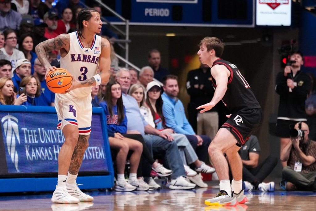 Dec 22, 2025; Lawrence, Kansas, USA; Kansas Jayhawks guard Tre White (3) controls the ball as Davidson Wildcats guard Sam Brown (11) defends during the first half of the game at Allen Fieldhouse. Mandatory Credit: Denny Medley-Imagn Images