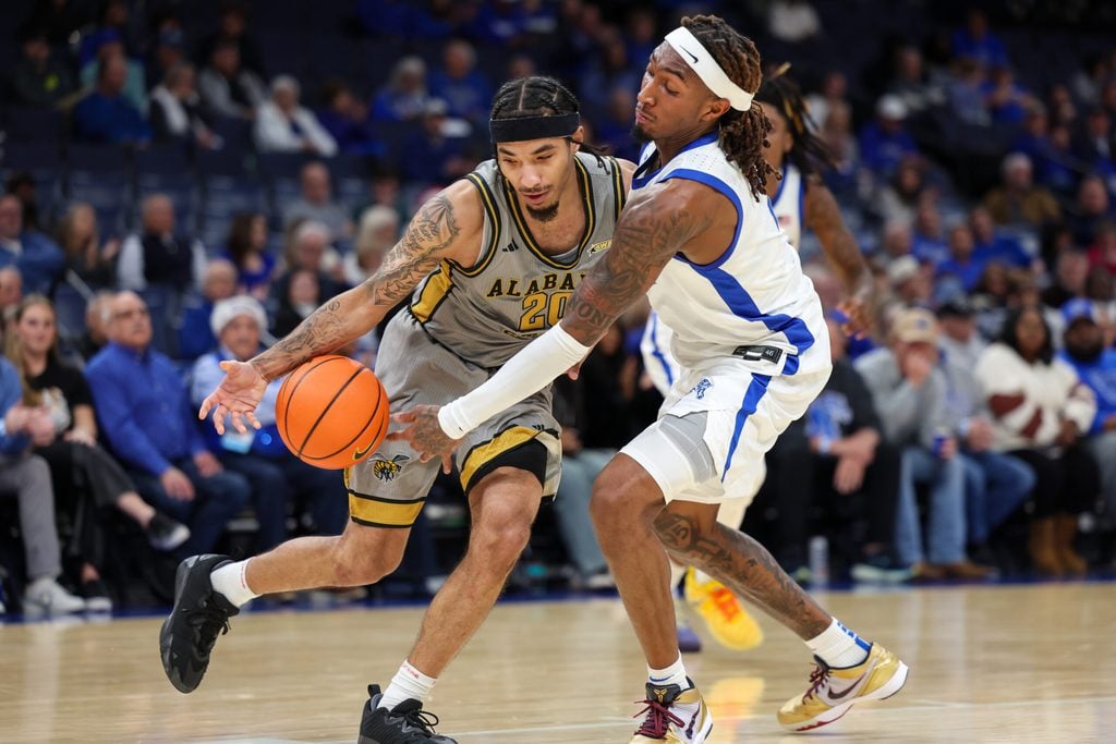 Dec 22, 2025; Memphis, Tennessee, USA; Alabama State Hornets guard Asjon Anderson (20) handles the ball against Memphis Tigers guard Zach Davis (2) during the second half at FedExForum. Mandatory Credit: Wesley Hale-Imagn Images