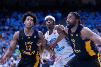 Dec 22, 2025; Chapel Hill, North Carolina, USA; North Carolina Tar Heels forward Caleb Wilson (8) battles with East Carolina Pirates guard Jordan Riley (12) and center Giovanni Emejuru (7) during the second half at Dean E. Smith Center. Mandatory Credit: Scott Kinser-Imagn Images