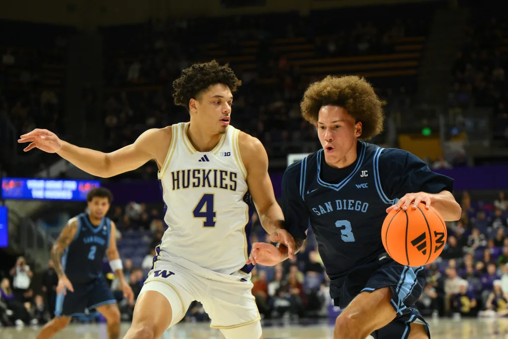 Dec 22, 2025; Seattle, Washington, USA; Washington Huskies forward Jasir Rencher (4) guards San Diego Toreros forward Darrae Goodwin (3) during the second half at Alaska Airlines Arena at Hec Edmundson Pavilion. Mandatory Credit: Steven Bisig-Imagn Images