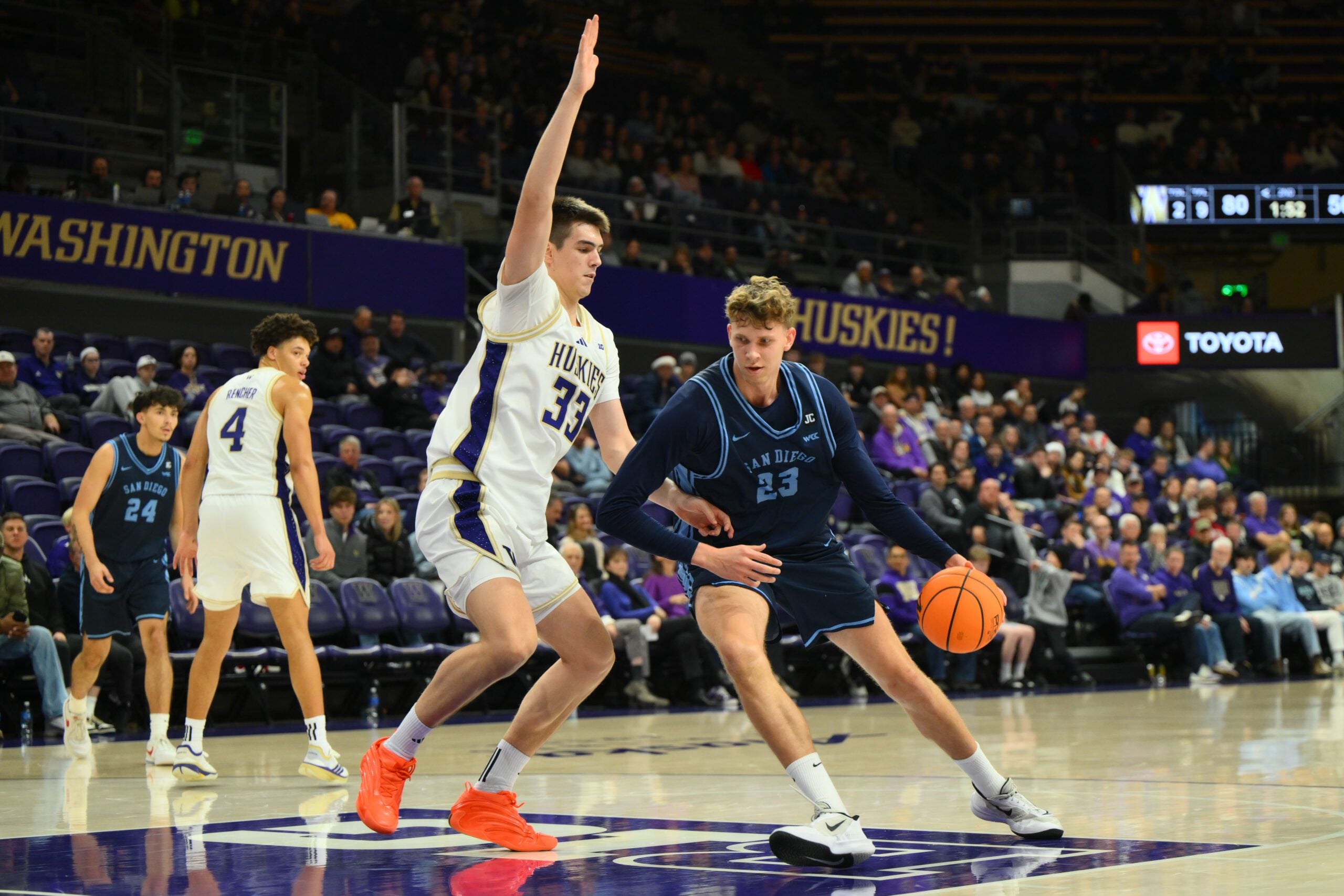 Dec 22, 2025; Seattle, Washington, USA; Washington Huskies forward Nikola Dzepina (33) defends San Diego Toreros center Piotr Winkowski (23) during the second half at Alaska Airlines Arena at Hec Edmundson Pavilion. Mandatory Credit: Steven Bisig-Imagn Images