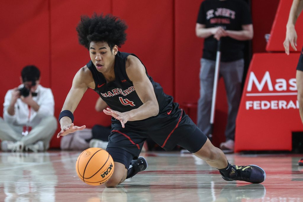 Dec 23, 2025; Queens, New York, USA; Harvard Crimson guard Robert Hinton (4) dives after a loose ball in the first half against the St. John's Red Storm at Carnesecca Arena. Mandatory Credit: Wendell Cruz-Imagn Images