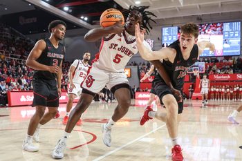 Dec 23, 2025; Queens, New York, USA;  St. John's Red Storm guard Kelvin Odih (5) and Harvard Crimson guard Frankie Mannino (10) fight for a loose ball in the second half at Carnesecca Arena. Mandatory Credit: Wendell Cruz-Imagn Images