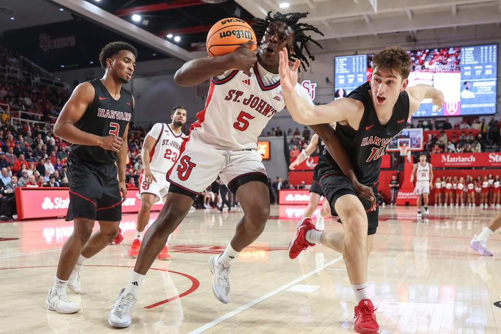 Dec 23, 2025; Queens, New York, USA; St. John's Red Storm guard Kelvin Odih (5) and Harvard Crimson guard Frankie Mannino (10) fight for a loose ball in the second half at Carnesecca Arena. Mandatory Credit: Wendell Cruz-Imagn Images