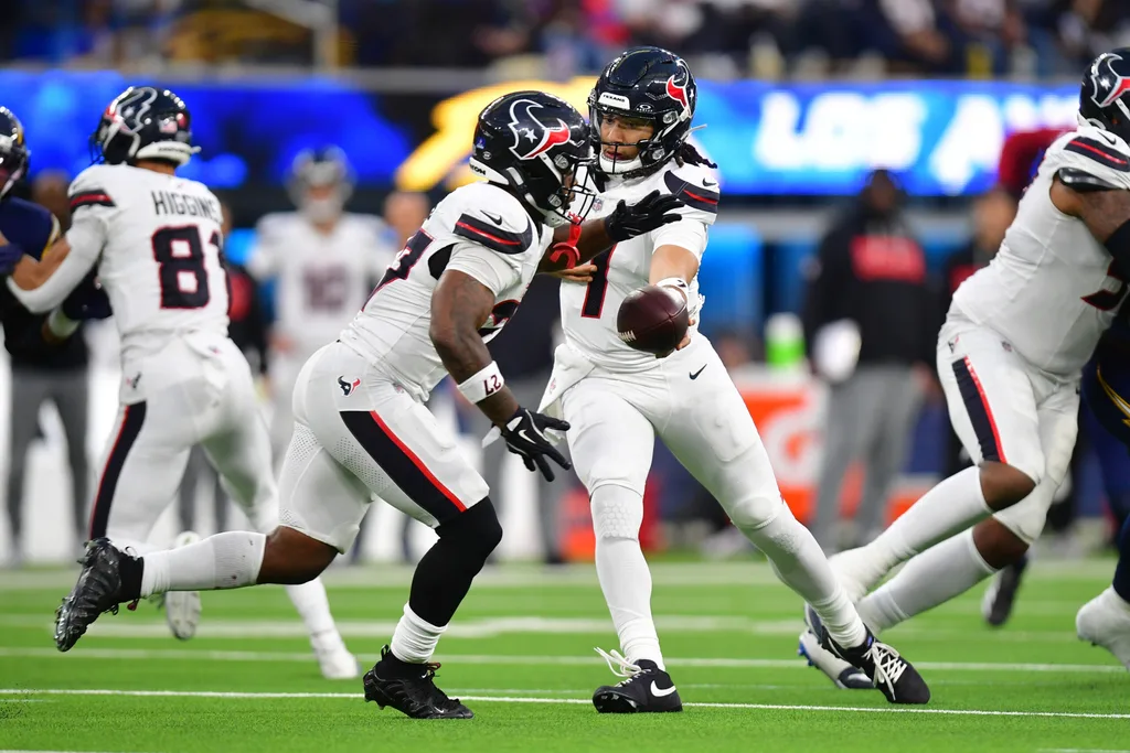 Dec 27, 2025; Inglewood, California, USA; Houston Texans running back Woody Marks (27) takes the hand off from quarterback C.J. Stroud (7) against the Los Angeles Chargers during the second half at SoFi Stadium. Mandatory Credit: Gary A. Vasquez-Imagn Images
