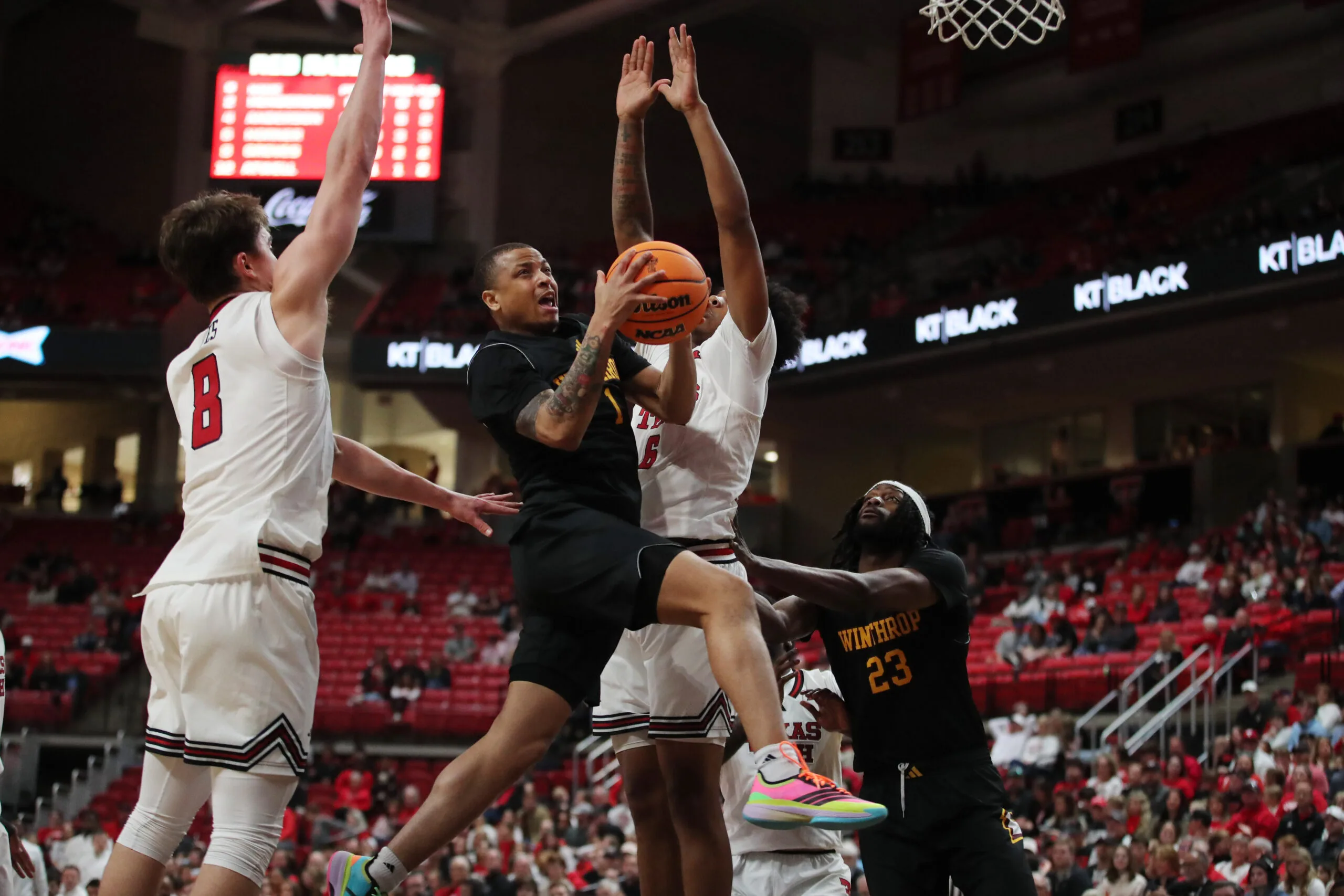 Dec 28, 2025; Lubbock, Texas, USA;  Winthrop Eagles guard Isaiah Wilson (1) drives to the basket between Texas Tech Red Raiders guard Nolan Groves (8) and forward Leon Horner (6) in the second half at United Supermarkets Arena. Mandatory Credit: Michael C. Johnson-Imagn Images