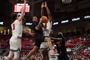 Dec 28, 2025; Lubbock, Texas, USA;  Winthrop Eagles guard Isaiah Wilson (1) drives to the basket between Texas Tech Red Raiders guard Nolan Groves (8) and forward Leon Horner (6) in the second half at United Supermarkets Arena. Mandatory Credit: Michael C. Johnson-Imagn Images