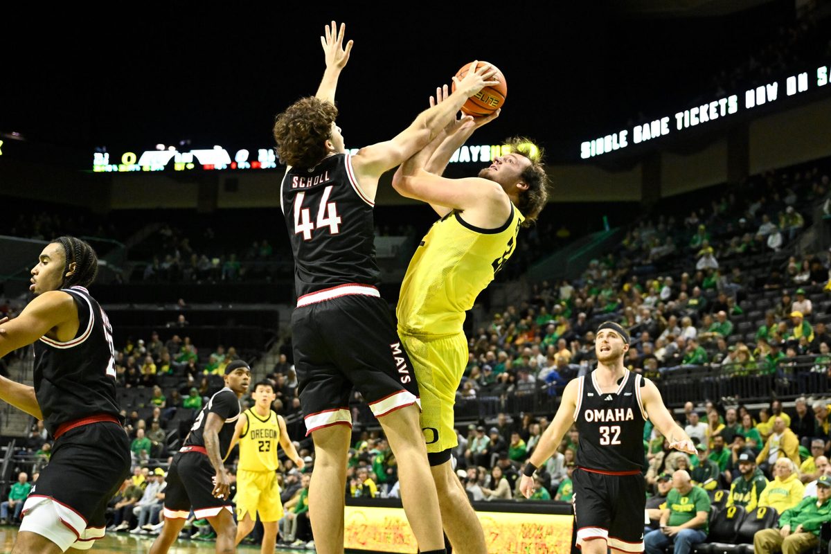 Dec 28, 2025; Eugene, Oregon, USA; Omaha Mavericks forward Brock Scholl (44) blocks a shot by Oregon Ducks center Nate Bittle (32) but is called for a foul during the first half at Matthew Knight Arena. Mandatory Credit: Craig Strobeck-Imagn Images