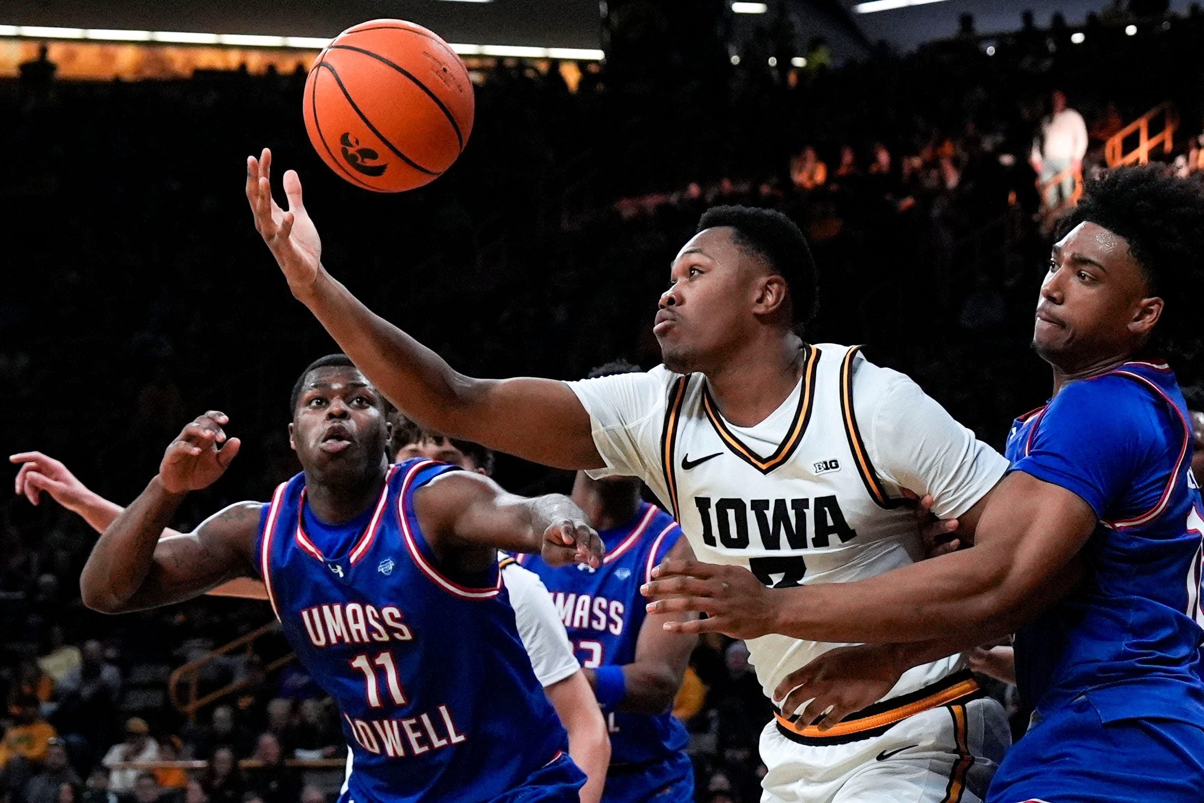Iowa forward Cam Manyawu (3) reaches for a loose ball against UMass Lowell guard Xavier Spencer (11) and UMass Lowell forward Austin Green (10) Dec. 29, 2025 at Carver-Hawkeye Arena in Iowa City, Iowa.
