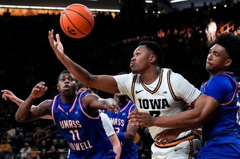 Iowa forward Cam Manyawu (3) reaches for a loose ball against UMass Lowell guard Xavier Spencer (11) and UMass Lowell forward Austin Green (10) Dec. 29, 2025 at Carver-Hawkeye Arena in Iowa City, Iowa.