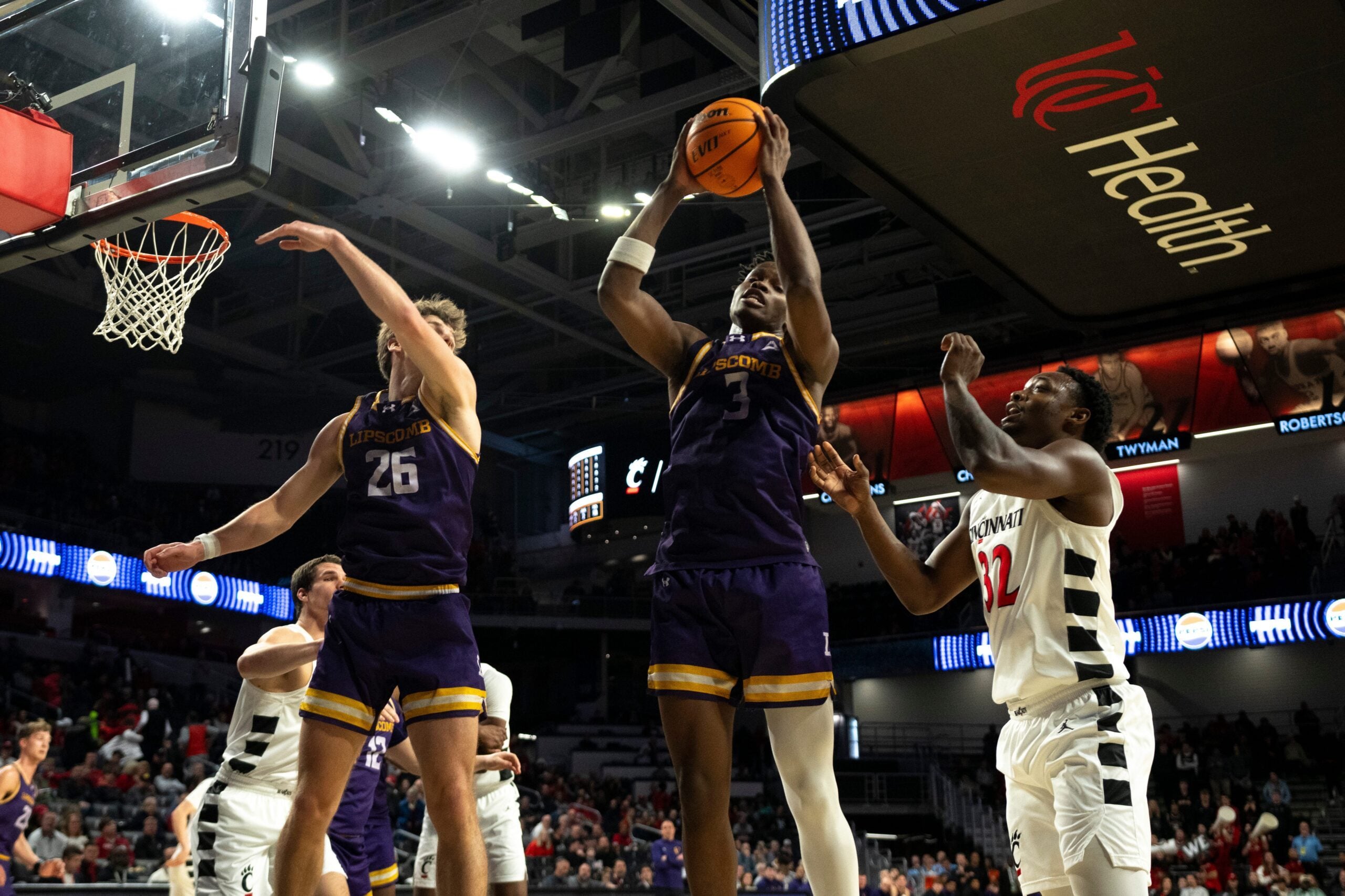 Lipscomb Bisons forward Kennedy Okpara (3) grabs a rebound over Cincinnati Bearcats guard Jalen Celestine (32) in the second half of the NCAA basketball game at Fifth Third Arena in Cincinnati on Dec. 29, 2025.