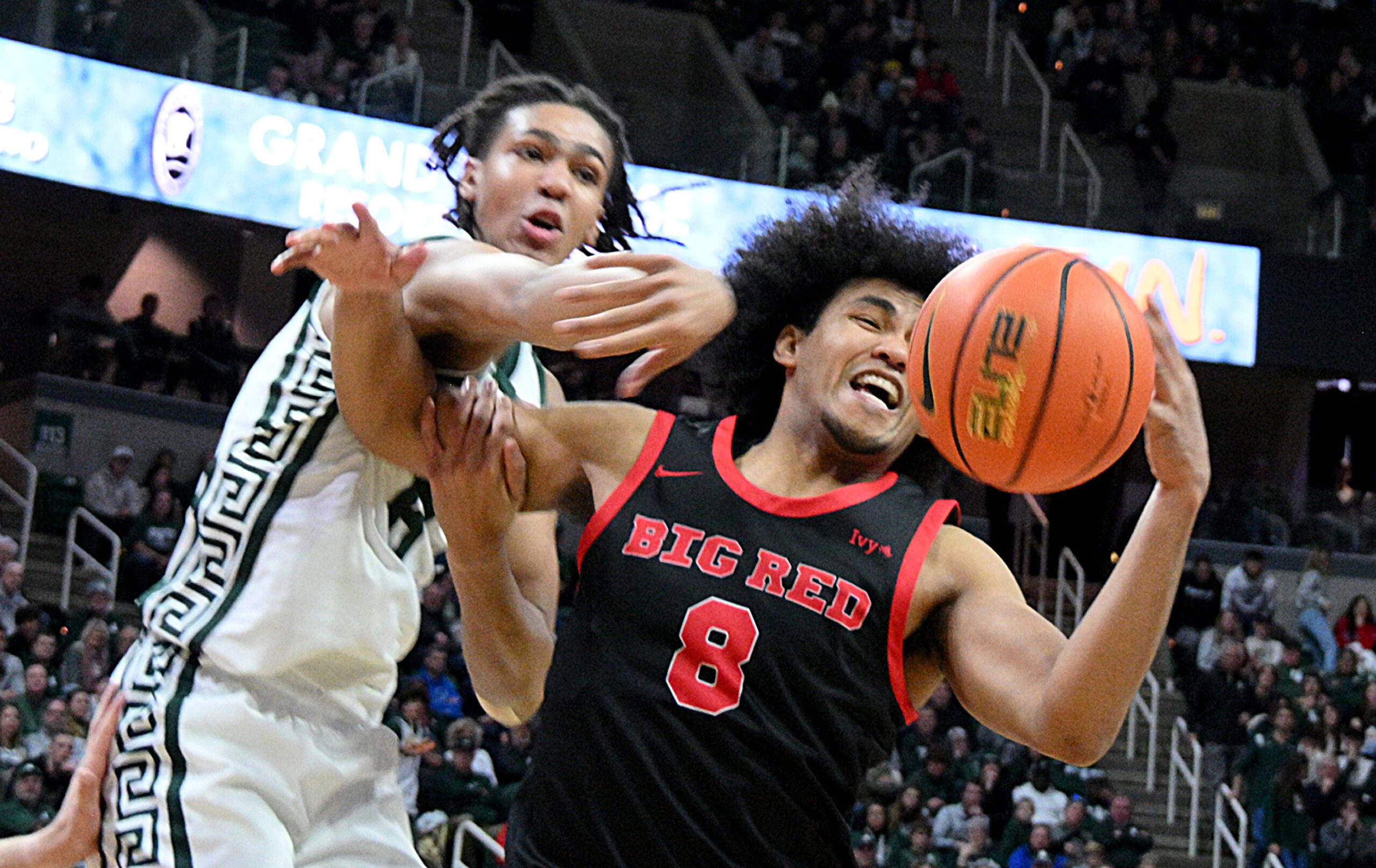 Dec 29, 2025; East Lansing, Michigan, USA;  Michigan State Spartans forward Kaleb Glenn (8) battles for a rebound with Cornell Big Red guard Adam Hinton (8) during the second half at Jack Breslin Student Events Center. Mandatory Credit: Dale Young-Imagn Images