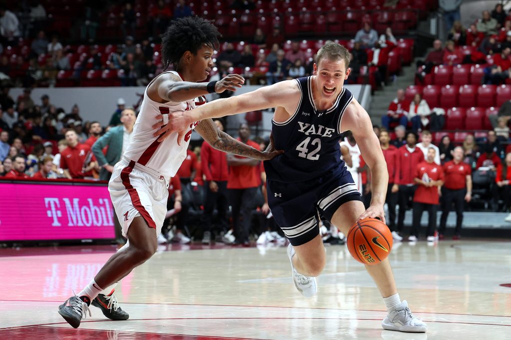 Dec 29, 2025; Tuscaloosa, Alabama, USA; Yale Bulldogs forward Nick Townsend (42) dribbles against Alabama Crimson Tide guard Aden Holloway (2) during the second half at Coleman Coliseum. Mandatory Credit: David Leong-Imagn Images
