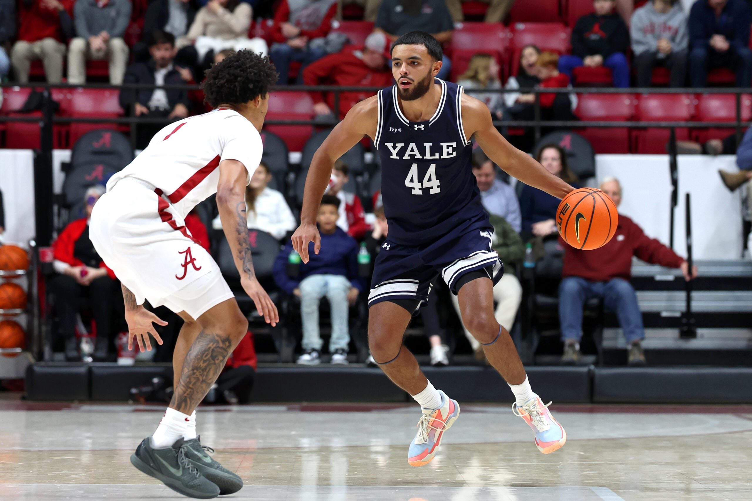 Dec 29, 2025; Tuscaloosa, Alabama, USA; Yale Bulldogs guard Devon Arlington (44) dribbles against Alabama Crimson Tide guard Jalil Bethea (1) during the second half at Coleman Coliseum. Mandatory Credit: David Leong-Imagn Images