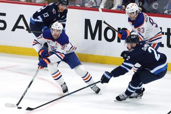 Dec 29, 2025; Winnipeg, Manitoba, CAN; Edmonton Oilers center Connor McDavid (97) is stick checked by Winnipeg Jets defenseman Dylan Demelo (2) in the third period at Canada Life Centre. Mandatory Credit: James Carey Lauder-Imagn Images