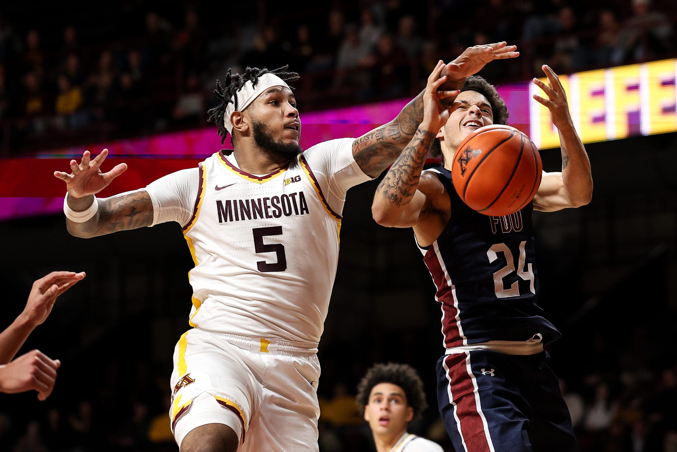 Dec 29, 2025; Minneapolis, Minnesota, USA; Minnesota Golden Gophers forward Jaylen Crocker-Johnson (5) blocks a shot by Fairleigh Dickinson Knights guard Ras Elijah Godbolt (24) during the second half at Williams Arena. Mandatory Credit: Matt Krohn-Imagn Images