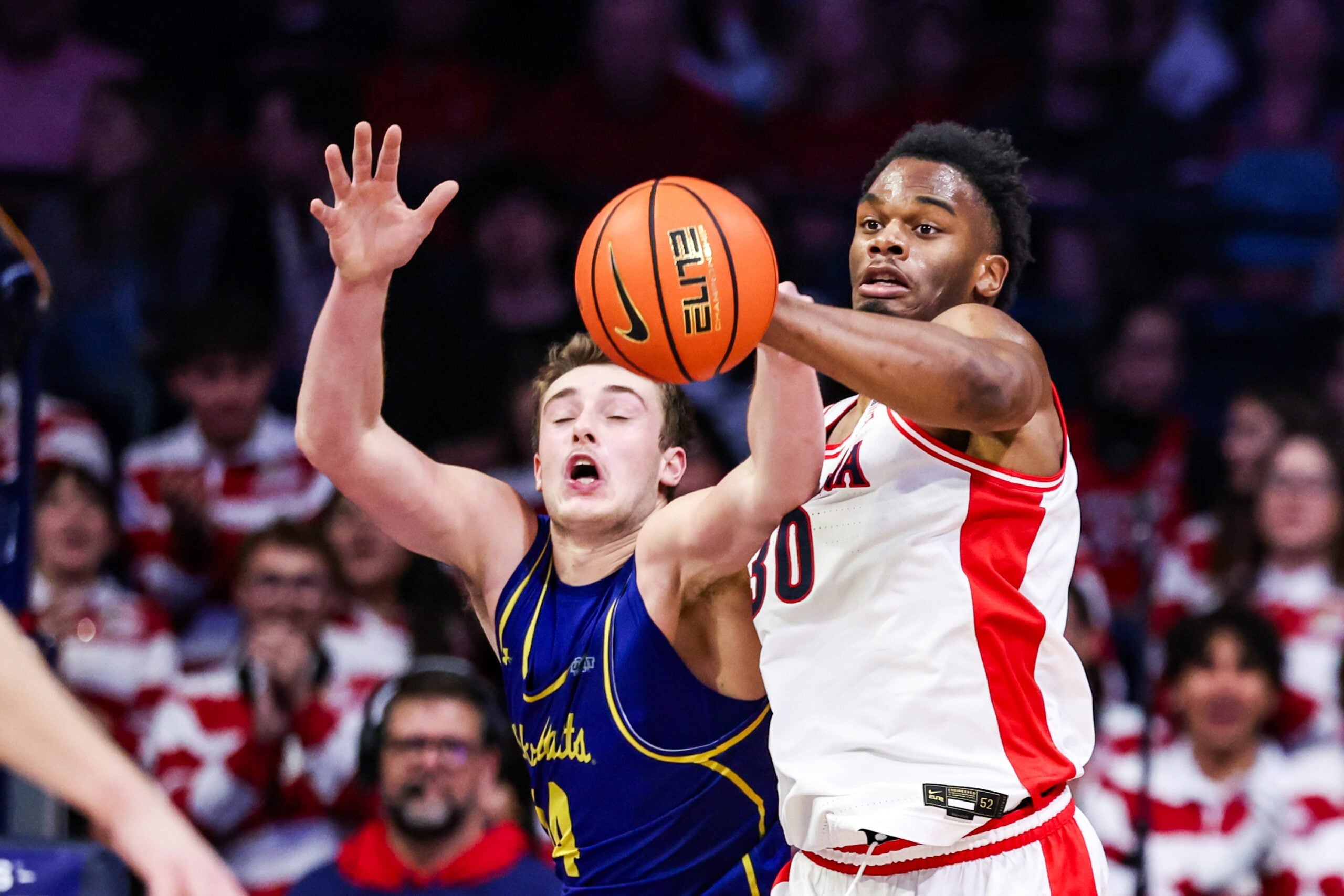 Dec 29, 2025; Tucson, Arizona, USA; South Dakota State Jackrabbits center Damon Wilkinson (34) and Arizona Wildcats forward Tobe Awaka (30) attempt to catch the ball during the second half of the game at McKale Memorial Center. Mandatory Credit: Aryanna Frank-Imagn Images