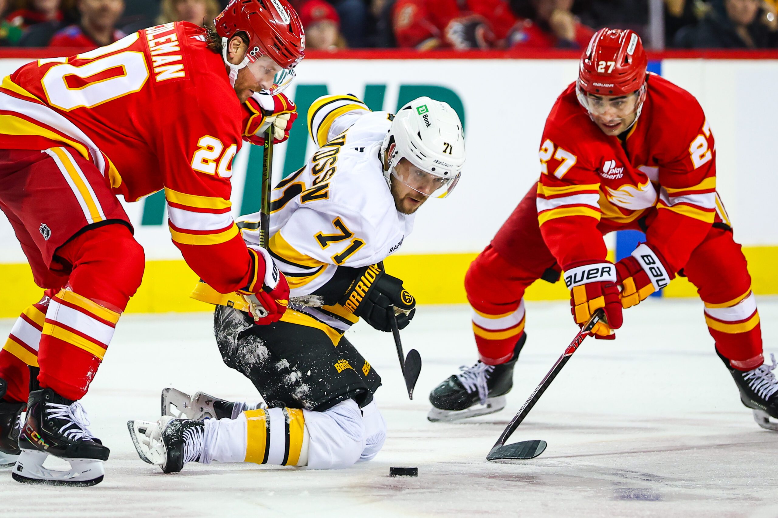 Dec 29, 2025; Calgary, Alberta, CAN; Boston Bruins left wing Viktor Arvidsson (71) battle for the puck against Calgary Flames left wing Blake Coleman (20) and right wing Matt Coronato (27) during the third period at Scotiabank Saddledome. Mandatory Credit: Sergei Belski-Imagn Images