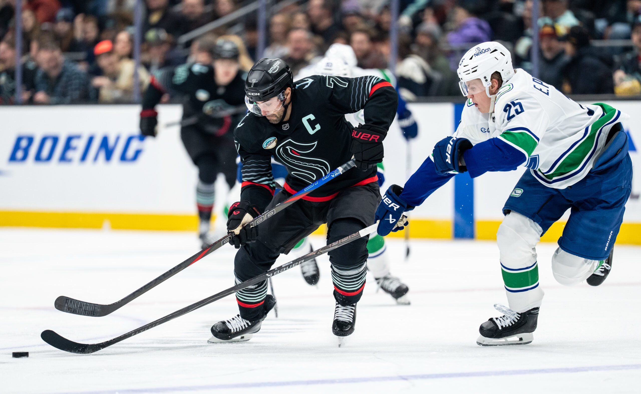 Dec 29, 2025; Seattle, Washington, USA; Seattle Kraken forward Jordan Eberle (7) battles Vancouver Canucks defenseman Elias Pettersson (25) for the puck during the second period at Climate Pledge Arena. Mandatory Credit: Stephen Brashear-Imagn Images