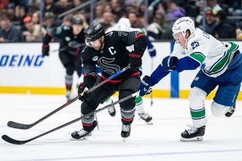 Dec 29, 2025; Seattle, Washington, USA; Seattle Kraken forward Jordan Eberle (7) battles Vancouver Canucks defenseman Elias Pettersson (25) for the puck during the second period at Climate Pledge Arena. Mandatory Credit: Stephen Brashear-Imagn Images