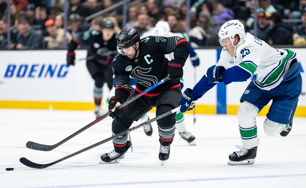 Dec 29, 2025; Seattle, Washington, USA; Seattle Kraken forward Jordan Eberle (7) battles Vancouver Canucks defenseman Elias Pettersson (25) for the puck during the second period at Climate Pledge Arena. Mandatory Credit: Stephen Brashear-Imagn Images