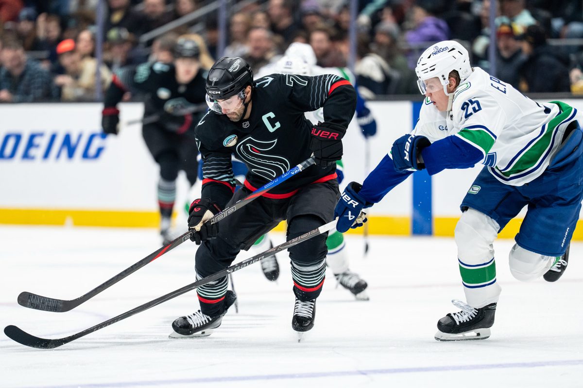 Dec 29, 2025; Seattle, Washington, USA; Seattle Kraken forward Jordan Eberle (7) battles Vancouver Canucks defenseman Elias Pettersson (25) for the puck during the second period at Climate Pledge Arena. Mandatory Credit: Stephen Brashear-Imagn Images