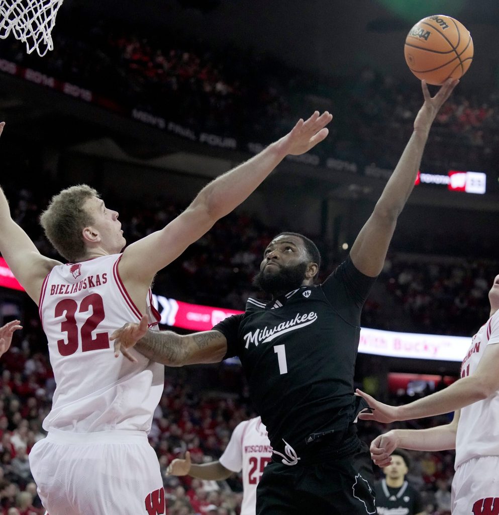 UW-Milwaukee guard Amar Augillard (1) scores on Wisconsin forward Aleksas Bieliauskas (32) during the first half of their game Tuesday, December 30, 2025 at the Kohl Center in Madison, Wisconsin.