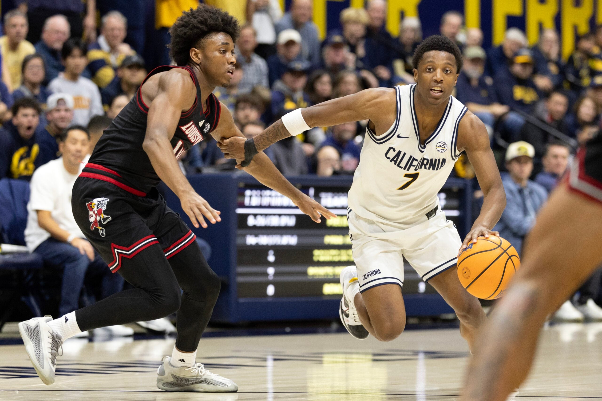 Dec 30, 2025; Berkeley, California, USA; California Golden Bears guard Dai Dai Ames (7) drives past Louisville Cardinals guard Adrian Wooley (14) during the second half at Haas Pavilion. Mandatory Credit: D. Ross Cameron-Imagn Images
