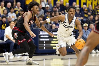 Dec 30, 2025; Berkeley, California, USA; California Golden Bears guard Dai Dai Ames (7) drives past Louisville Cardinals guard Adrian Wooley (14) during the second half at Haas Pavilion. Mandatory Credit: D. Ross Cameron-Imagn Images