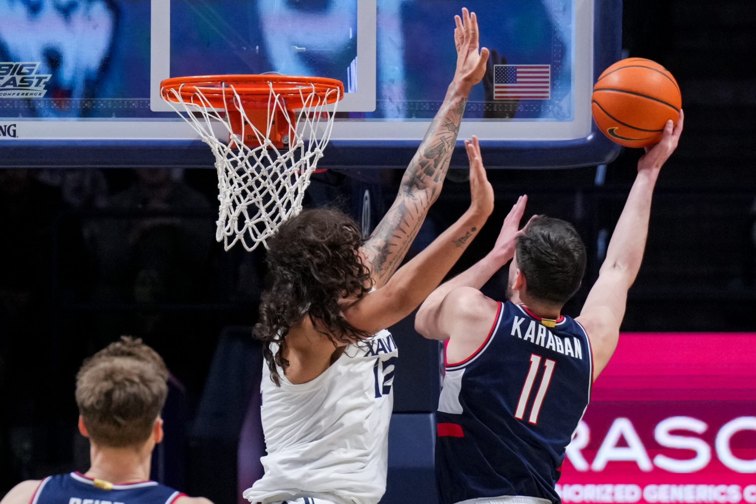 Dec 31, 2025; Cincinnati, Ohio, USA;  UConn Huskies forward Alex Karaban (11) drives to the basket against Xavier Musketeers forward Tre Carroll (12) in the first half at the Cintas Center. Mandatory Credit: Aaron Doster-Imagn Images