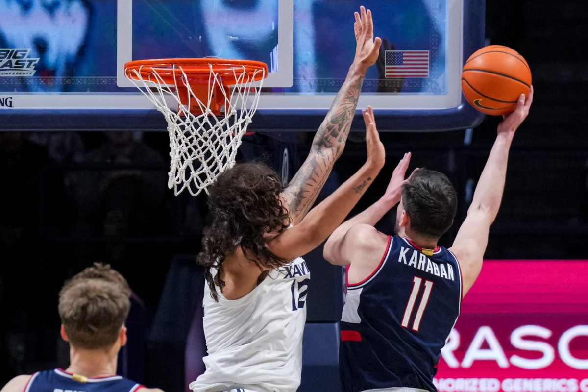 Dec 31, 2025; Cincinnati, Ohio, USA;  UConn Huskies forward Alex Karaban (11) drives to the basket against Xavier Musketeers forward Tre Carroll (12) in the first half at the Cintas Center. Mandatory Credit: Aaron Doster-Imagn Images