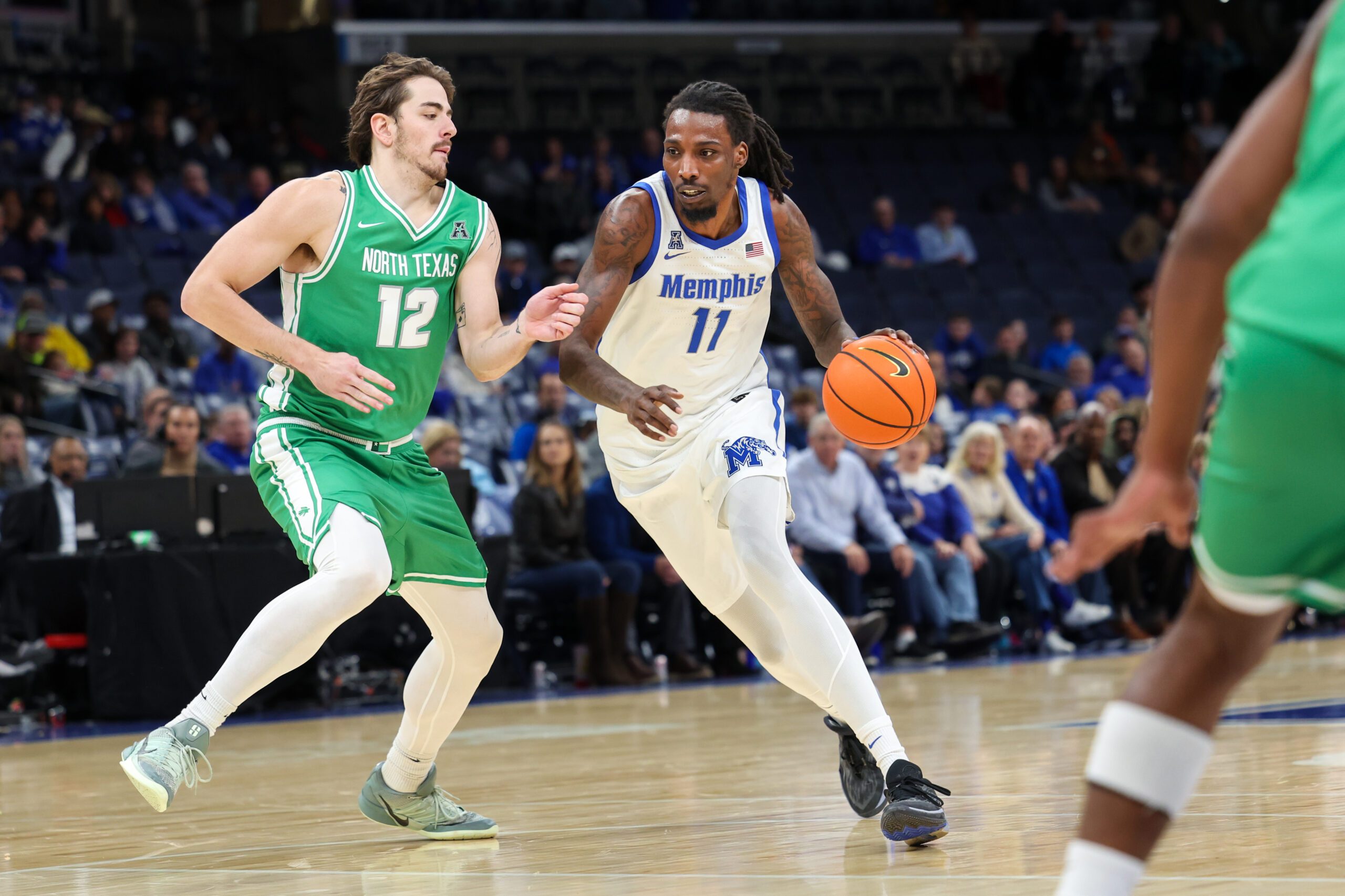 Dec 31, 2025; Memphis, Tennessee, USA; Memphis Tigers forward Aaron Bradshaw (11) drives against North Texas Mean Green forward Dylan Arnett (12) during the second half at FedExForum. Mandatory Credit: Wesley Hale-Imagn Images