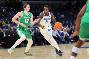 Dec 31, 2025; Memphis, Tennessee, USA; Memphis Tigers forward Aaron Bradshaw (11) drives against North Texas Mean Green forward Dylan Arnett (12) during the second half at FedExForum. Mandatory Credit: Wesley Hale-Imagn Images