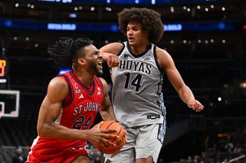 Dec 31, 2025; Washington, District of Columbia, USA; St. John's Red Storm forward Zuby Ejiofor (24) drives to the basket as Georgetown Hoyas center Seal Diouf (14) defends during the first half at Capital One Arena. Mandatory Credit: Brad Mills-Imagn Images