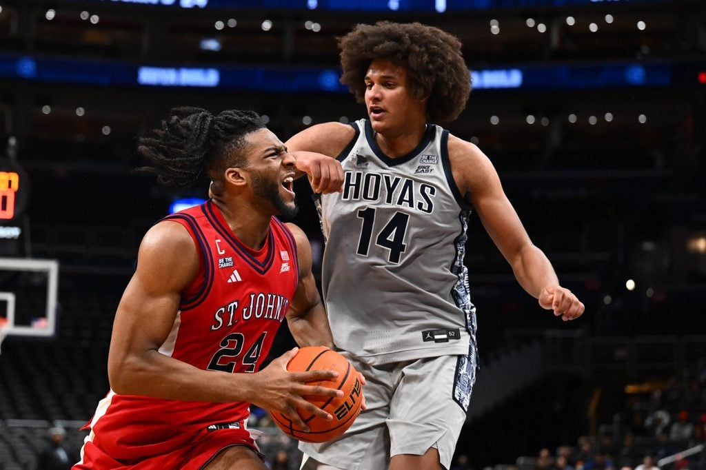 Dec 31, 2025; Washington, District of Columbia, USA; St. John's Red Storm forward Zuby Ejiofor (24) drives to the basket as Georgetown Hoyas center Seal Diouf (14) defends during the first half at Capital One Arena. Mandatory Credit: Brad Mills-Imagn Images