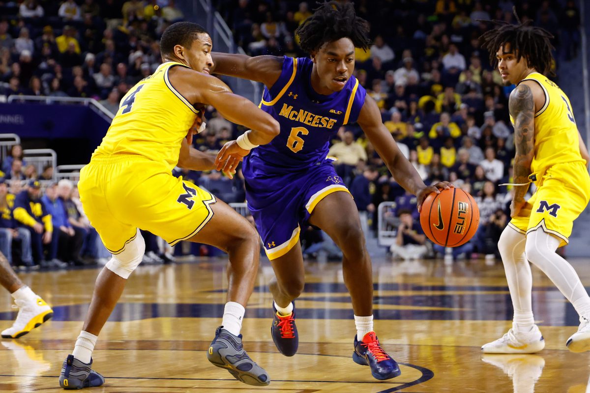 Dec 29, 2025; Ann Arbor, Michigan, USA;  McNeese Cowboys guard Larry Johnson (6) dribbles defended by Michigan Wolverines guard Nimari Burnett (4) at Crisler Center. Mandatory Credit: Rick Osentoski-Imagn Images