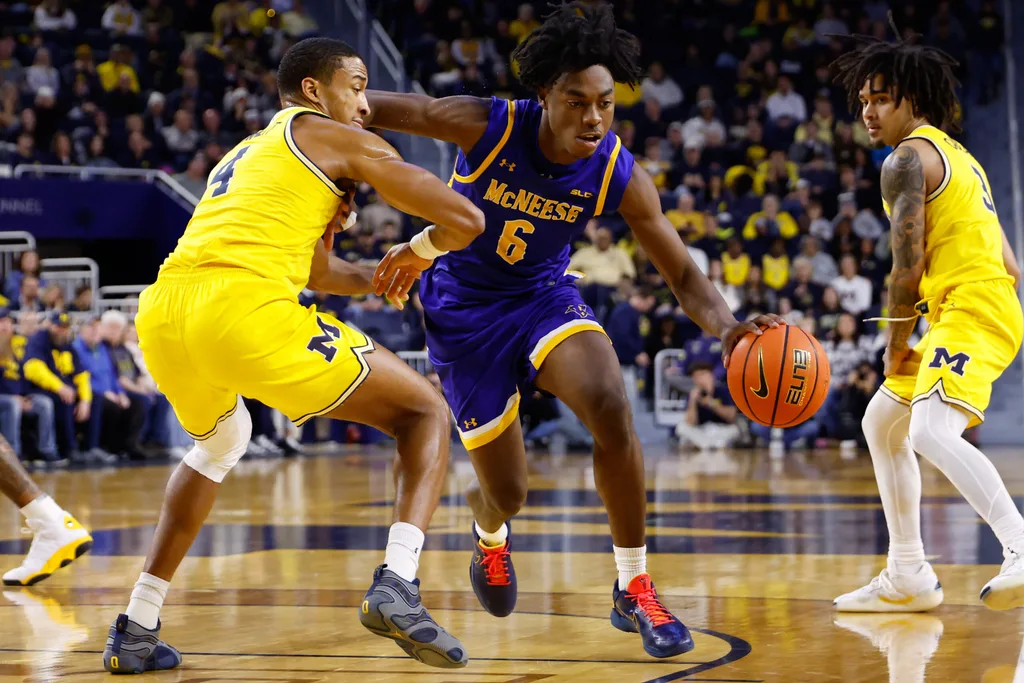 Dec 29, 2025; Ann Arbor, Michigan, USA; McNeese Cowboys guard Larry Johnson (6) dribbles defended by Michigan Wolverines guard Nimari Burnett (4) at Crisler Center. Mandatory Credit: Rick Osentoski-Imagn Images