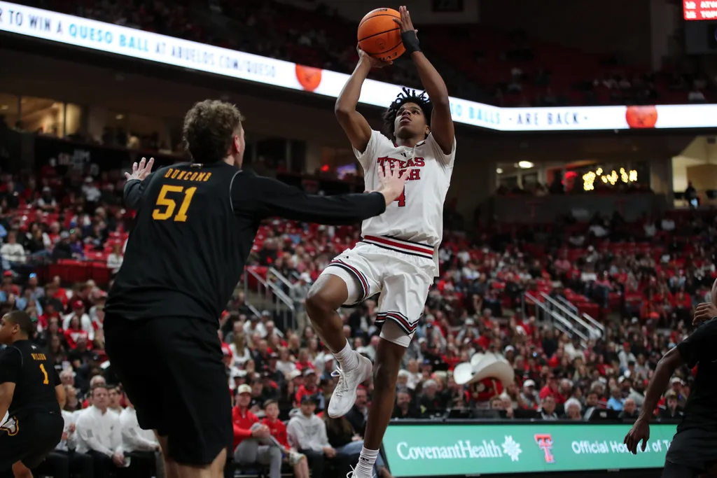Dec 28, 2025; Lubbock, Texas, USA; Texas Tech Red Raiders guard Christian Anderson (4) goes to the basket against Winthrop Eagles center Logan Duncomb (51) in the second half at United Supermarkets Arena. Mandatory Credit: Michael C. Johnson-Imagn Images