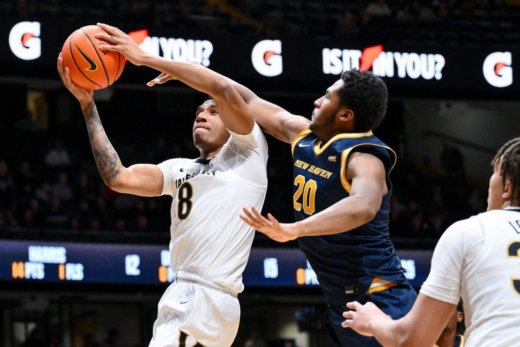 Dec 29, 2025; Nashville, Tennessee, USA; Vanderbilt Commodores guard Tyler Harris (8) lays the ball in over New Haven Chargers forward Tristian Burth (20) during the second half at Memorial Gymnasium. Mandatory Credit: Steve Roberts-Imagn Images